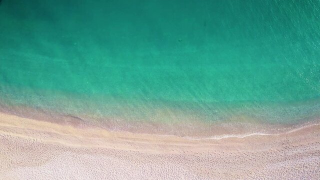 Sandy sea beach with clear turquoise water. Aerial drone shot. Dream travel destination. UHD, 4K