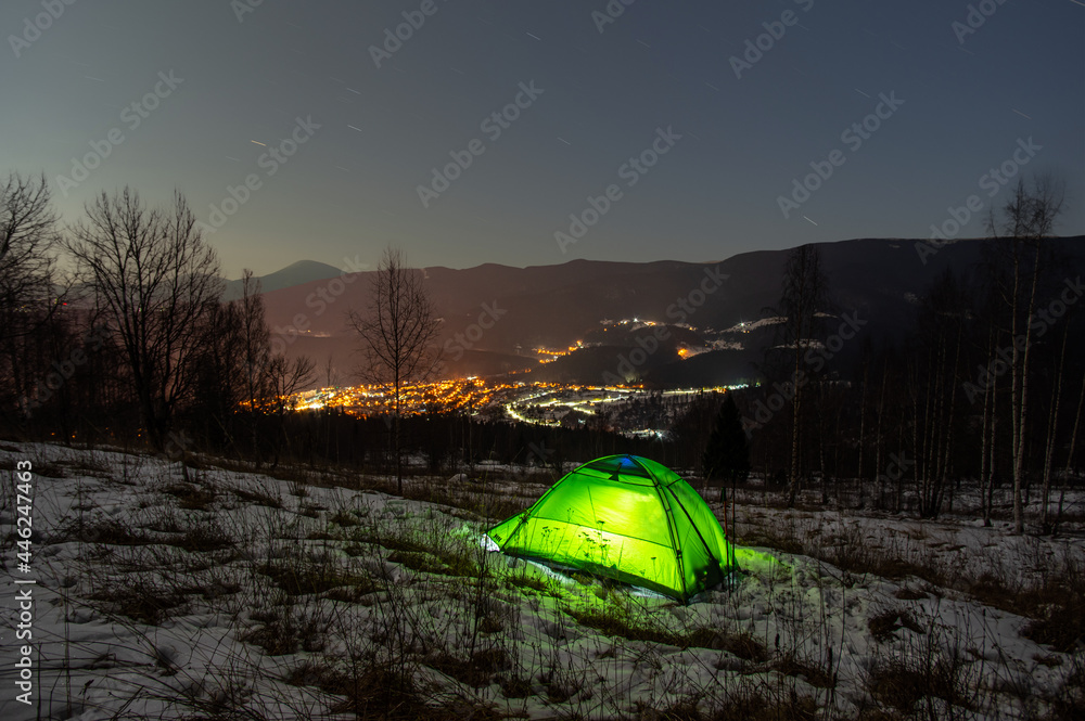 Wall mural tent in the winter in the mountains with a view of the night city