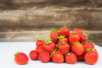 Heap of fresh red ripe strawberries on a wooden background
