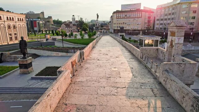 Camera moves along old bridge in Skopje, North Macedonia, in morning lights. Panoramic flight in center of capital of Macedonia - Skopje