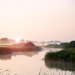 Sunrise in a light fog on a small river. Selective Focus