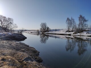 frozen lake in winter with blue sky and reflection