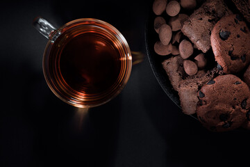 Time for tea. Cup and cookies on black background.