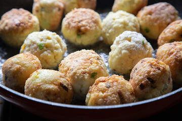 Golden brown breadfruit balls in a frying pan
