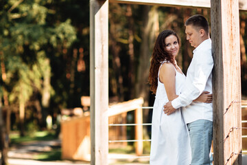 Fototapeta premium Portrait of cheerful woman and man spending time together outdoors, kissing, hugging and laughing on summer terrace, couple in love on valentine's day togetherness