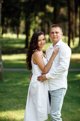 Fototapeta premium young couple in love is hugging in the park on a summer day. man and woman outdoors
