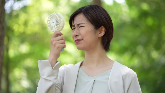 ハンディファンを使う女性