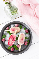 Homemade Raspberry Banana Popsicles with Coconut Milk. Homemade and healthy ice cream. Vegan ice cream with fresh fruit and mint leaves
