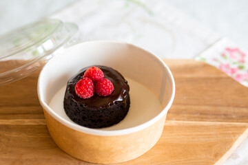 Dessert delivery in a carton box.Chocolate fondant with you.Delivery of chocolate dessert.Fondant with you.Cupcake with fondant lava in a box.Warm chocolate dessert.Takeaway sweet.Cupcake with berries