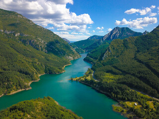 Aerial drone view of an idyllic and natural valley with a big lake in the mountains of north Spain.