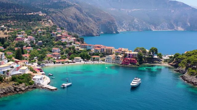 Beautiful aerial view to the picturesque fishing village of Assos, Kefalonia, Greece, with sailing boats moored over the turquoise sea