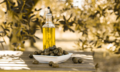 green olives and oil on table in olive grove