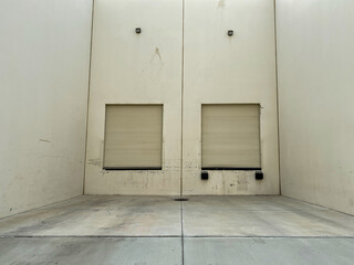 industrial shipping area of a factory warehouse with 2 closed receiving roll up doors