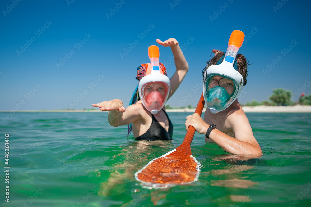 Wall mural man and woman in the sea in a mask for diving in the summer