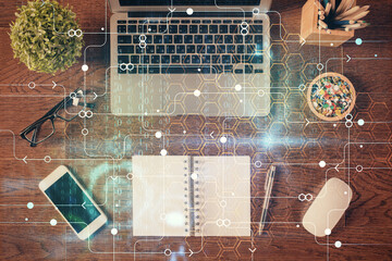 Double exposure of data theme drawing hologram over topview work table background with computer....