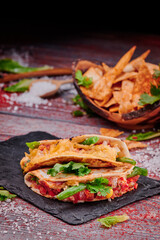 Crispy tacos with salsa on a wooden red background. Mexican food and fast food. High quality photo