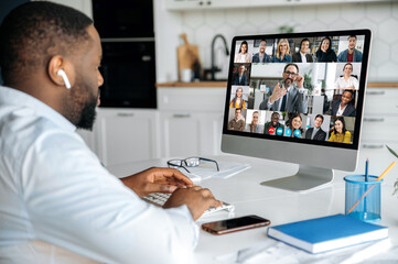 Fototapeta na wymiar Online conversation by video conference. African American business man has a virtual meeting with multiracial business colleagues, discussing financial strategy, talking on a video call, brainstorming