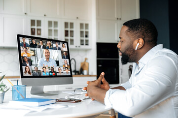 Fototapeta na wymiar Distant meeting, online communication. African American business man has a virtual meeting with multiracial business colleagues, discussing financial strategy, talking on a video call, brainstorming