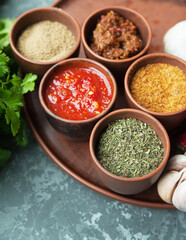 Georgian spices in clay jars on a plate.
