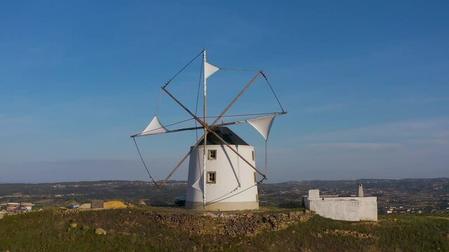 Aerial view The ancient windmills, Portugal. This is typical windmills, located in the on the hills in Portugal.
Circular tower mill has four trapezoidal sails made of wood. The four lattice framework