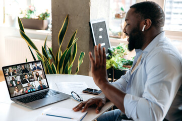 Virtual online meeting by video call. African American man communicating via video conference with...