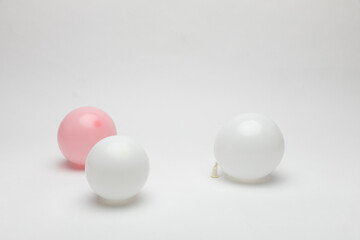 Small balloons in white, pink colors on a white background.