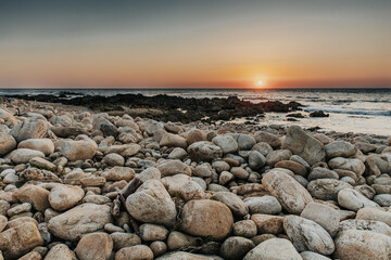Mesmerizing sunset above the sea seen through coastal rock
