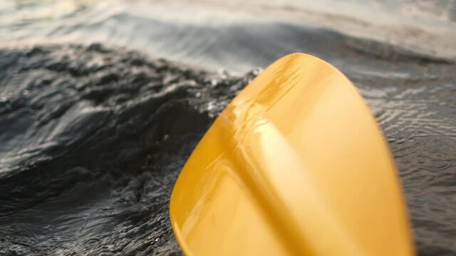 Kayak paddle water drops.Yellow paddle close-up.