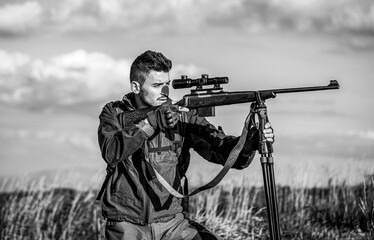 Fototapeta premium Hunter man. Shooter sighting in the target. Hunting period. Male with a gun. Close up. The man is on the hunt. Hunt hunting rifle. Black and white