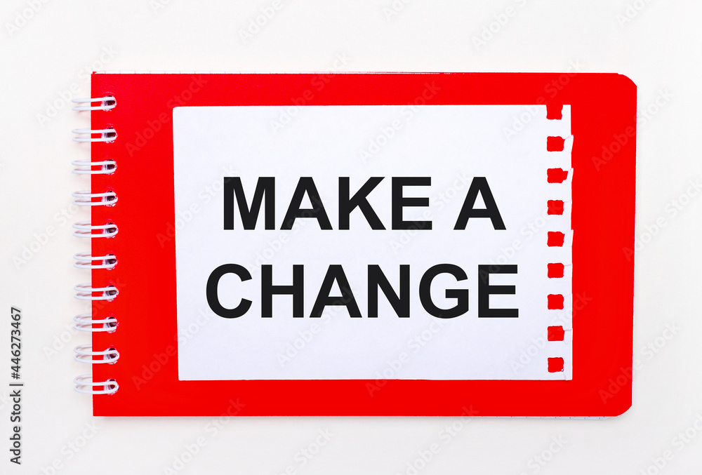 Poster on a white background - a bright red notebook on a spiral. on it is a white sheet of paper with the 
