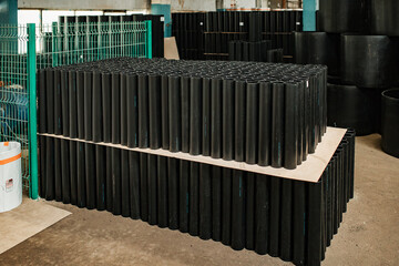 warehouse of black plastic and metal pipes. a plant for the production of pipelines. products...