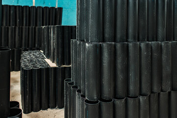 warehouse of black plastic and metal pipes. a plant for the production of pipelines. products...