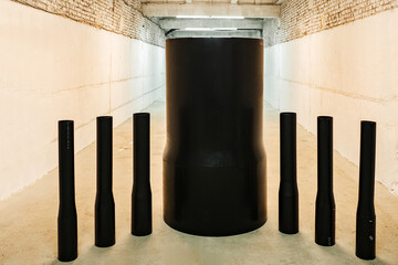 black cylindrical plastic pipes of different diameters are in stock. exhibition samples of the...