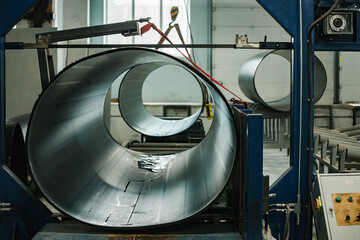 a worker of a pipe-rolling plant. conveyor line of the ferrous metallurgy enterprise. a worker in a...