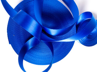 two rolls of thick and curly blue satin ribbon isolated on a white background. coarse textured ribbon. 