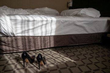 黒いエナメルのハイヒールとダブルベッド　情事のイメージ　black shiny high heels in the bed room