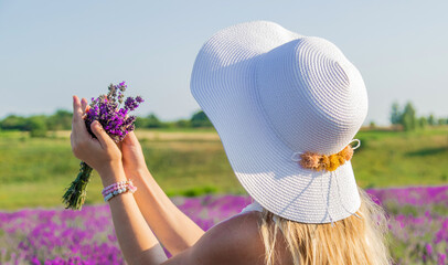 Woman with hat in lavender field. Selective focus.