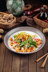 Russian malibu salad with croutons and ham on wooden background