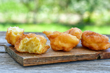 Traditional Bulgarian home made deep fried  patties  covered with sugar  оn rustic backgroud.Mekitsa or Mekica,  on wooden  rustic  background. Made of kneaded dough that is deep fried 