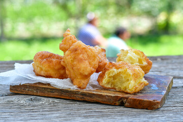 Traditional Bulgarian home made deep fried  patties  covered with sugar  оn rustic backgroud.Mekitsa or Mekica,  on wooden  rustic  background. Made of kneaded dough that is deep fried 