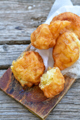 Traditional Bulgarian home made deep fried  patties  covered with sugar  оn rustic backgroud.Mekitsa or Mekica,  on wooden  rustic  background. Made of kneaded dough that is deep fried 