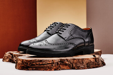 Black leather men's shoes made of genuine leather in classic style on a wooden cut. Close-up. High quality photo
