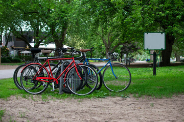 bicycles parked in a park with a blank sign