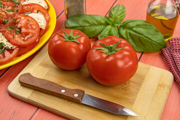 deux tomates crues et branches de basilic frais sur une table