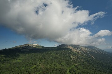 AERIAL: an epic panorama of mountains with thunderclouds. shot of adventure hiking in mountains alone outdoor active lifestyle travel vacations. Conceptual scene