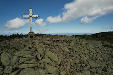 an old building on the top of a mountain in the summer at a ski resort. a sign for the conquerors of the top of tourist mountaineering