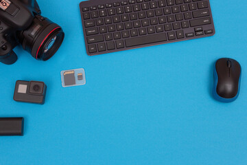 Top View of Photographer's, Videographer's or Video Blogger's Workplace. Digital Gadgets Lying on Blue Table - Flat Lay