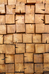 Wooden, textured wall lined with wooden cubes, longitudinal cuts of a fir tree. Vertical photo.