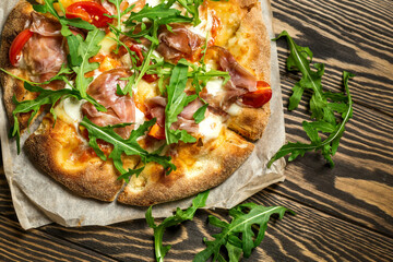 Prosciutto pizza with  strachatella cheese on woods