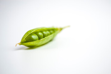green ripe peas, green beans on a white background, vegetarian food close up